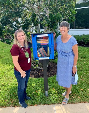 Mackle Park's Samantha Malloy, left, and DAR member Peggy Eckhold present Marco Island's first Little Free Library installed at Mackle Park.