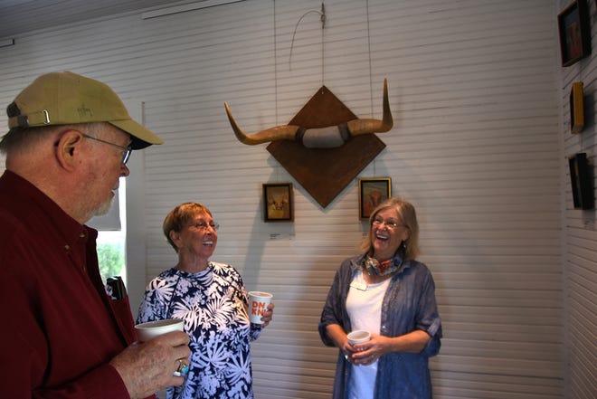 Jo-Ann Sanborn, right, enjoys a moment with Ron and Jean Bell. The Marco Island artist is having an exhibit of her cow paintings, titled “Florida on the Hoof,” at Roberts Ranch museum in Immokalee.