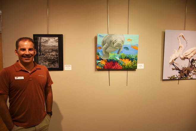 Friends of Rookery Bay executive director Athan Barkoukis with some of the works in "Rediscover Rookery Bay," an exhibit of works by area artists. The Rookery Bay Environmental Learning Center has reopened, with new exhibits and activities, after being closed over a year due to COVID-19.