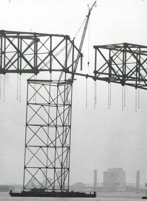 1967: A barge with scaffolding and crane assists with construction of the Hart Bridge over the St. Johns River.