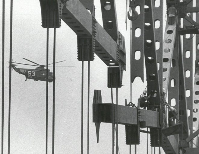 May 3, 1967: As a U.S. Navy helicopter hovers nearby, the imposing superstructures of the Hart Bridge are united as steelworkers bolt the last section of the lower chord in place.