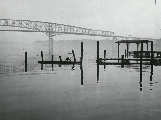 Nov. 10, 1969: Pilings along the watefront are silhouetted against a hazy sky with the Hart Bridge in the background.