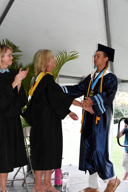 Co-valedictorian Johnathan Watt takes the stage again to receive his diploma and a hug from his proud mother, school founder Jane Watt. Marco Island Academy graduated its senior class Friday evening in a commencement ceremony at Veterans' Community Park.