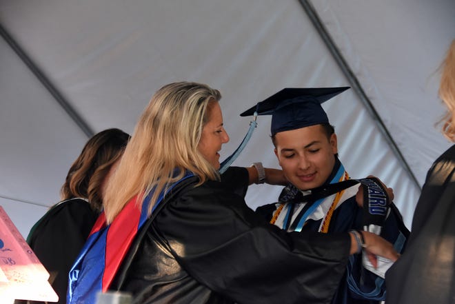 Peter Morales receives the Faculty Award from teacher Lori Galiana. Marco Island Academy graduated its senior class Friday evening in a commencement ceremony at Veterans' Community Park.