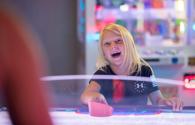 Tynslee Ogorzolka, 6, plays air hockey with her mom Tiffanee at FastTrax in south Fort Myers on Thursday, July 22, 2021. "We've been here three times since they opened last week," Tiffanee said.