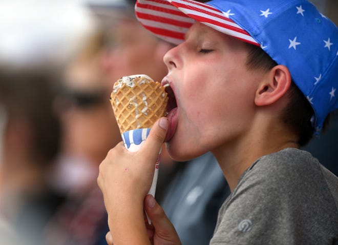 A fan keeps melting ice cream from falling down his cone during the American Legion Baseball tournament on Friday, July 23, 2021 at Aspen Park in Brandon.