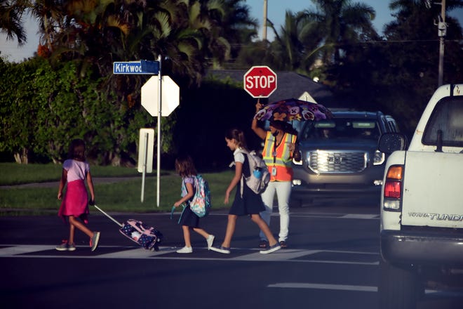 Children transit the crosswalk under the watchful eye of a crossing guard. Marco Island schoolchildren, along with all of Southwest Florida's public school students, returned for the new school year on Tuesday.