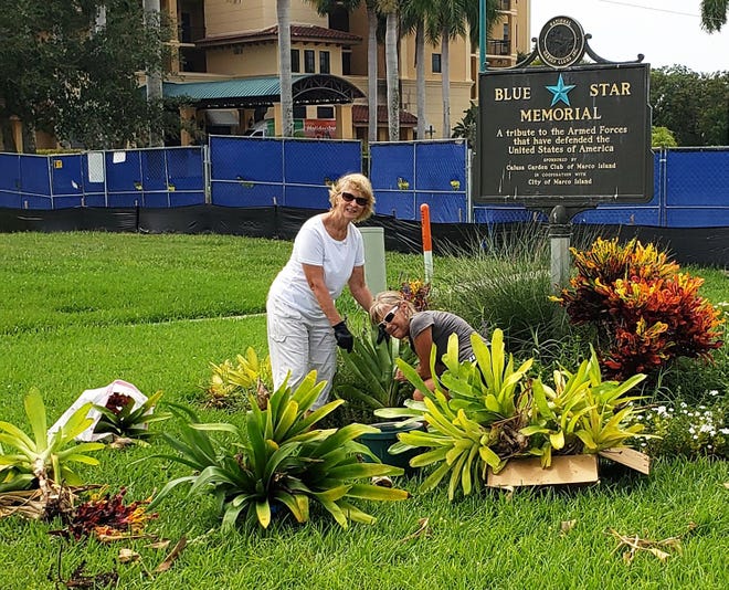 Linda Colombo and Margie Bramel work to remove the Blue Star Memorial.