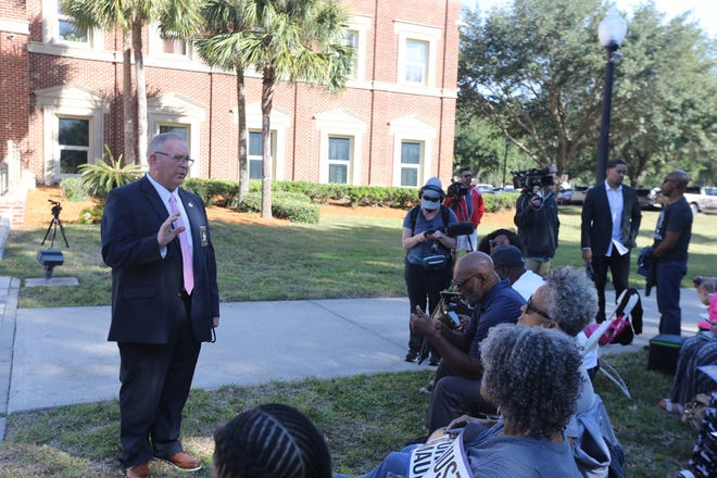 Glynn County Sheriff E. Neal Jump checks in with members of the Transformative Justice Coalition on Monday outside the Glynn County Courthouse.