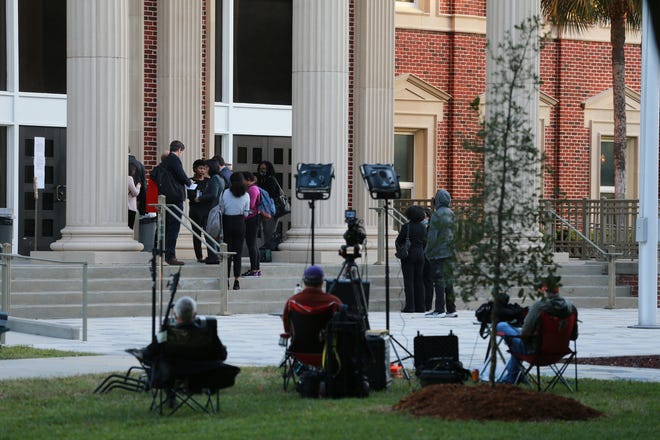 Members of the media line up to enter the Glynn County Courthouse Monday morning before pre-trial motion hearings in trial of the 3 men accused of killing Ahmaud Arbery.