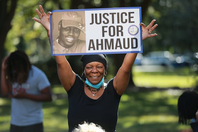 A member of the Transformative Justice Coalition holds a Justice for Ahmaud sign outside the Glynn County Courthouse on Monday.
