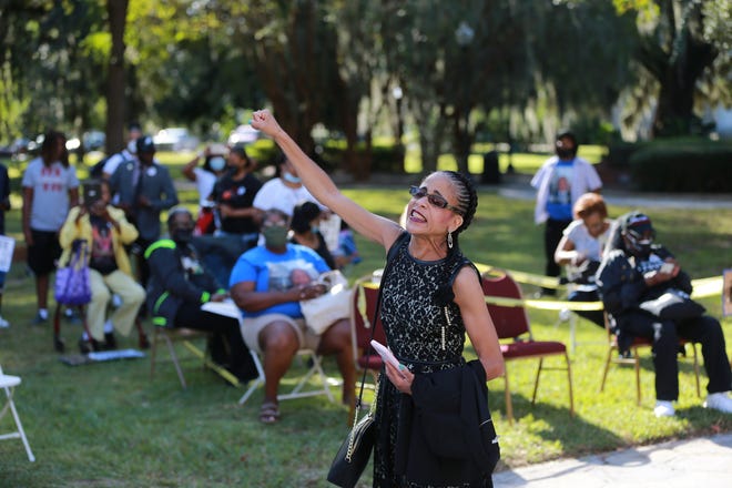 Desiree Whitfield leads a chant on Monday outside the Glynn County Courthouse as pre-trial motions are heard in the trial of the 3 men accused of killing Ahmaud Arbery in Brunswick Georgia.