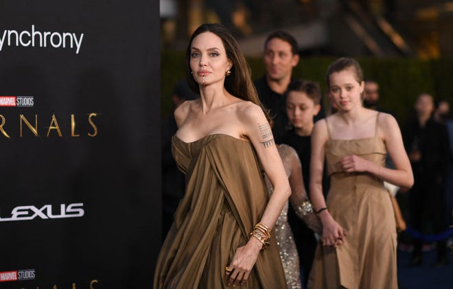 Jolie is pictured here with her children walking behind her.