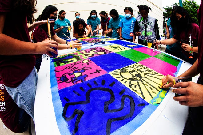 Students from the Immokalee Foundation paint a mural at Naples Art in Naples on Saturday. Nov. 20, 2021. The students took a tour of the Keith Haring exhibition at Naples Art and then painted a mural that will be on display at the gallery.