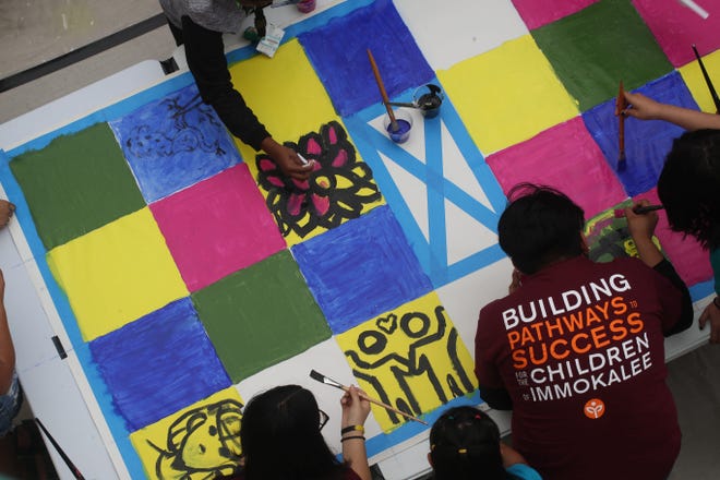 Students from the Immokalee Foundation paint a mural at Naples Art in Naples on Saturday. Nov. 20, 2021. The students took a tour of the Keith Haring exhibition at Naples Art and then painted a mural that will be on display at the gallery.