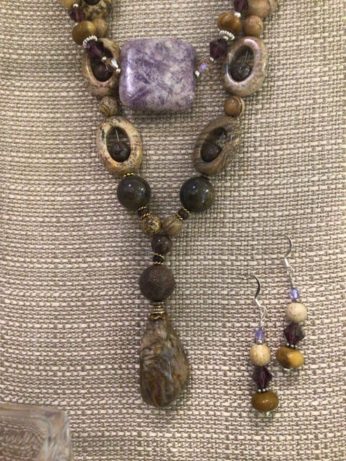 Hollowed stones hold a stone bead inside in this necklace with a double centerpiece stone, with earrings. $84 at Naples Art.
