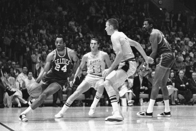Boston's Sam Jones, left, drives past the Lakers' Jerry West and drives along the baseline towards the basket in the teams' NBA playoff game in Los Angeles on May 2, 1968. At right are Darrall Imhoff of Lakers, who blocked the shot, and Celtics' Bill Russell. Basketball Hall of Famer Jones, the skilled scorer whose 10 NBA titles is second only to teammate Bill Russell, died on Thursday, Dec. 30, 2021, the team said. He was 88.
