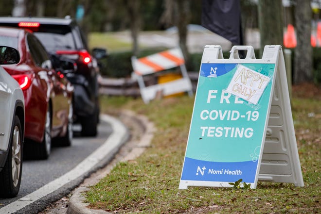 People wait in line in their vehicles to receive a COVID-19 test in the parking lot of the Lake Jackson library on Monday, Jan. 3, 2022.
