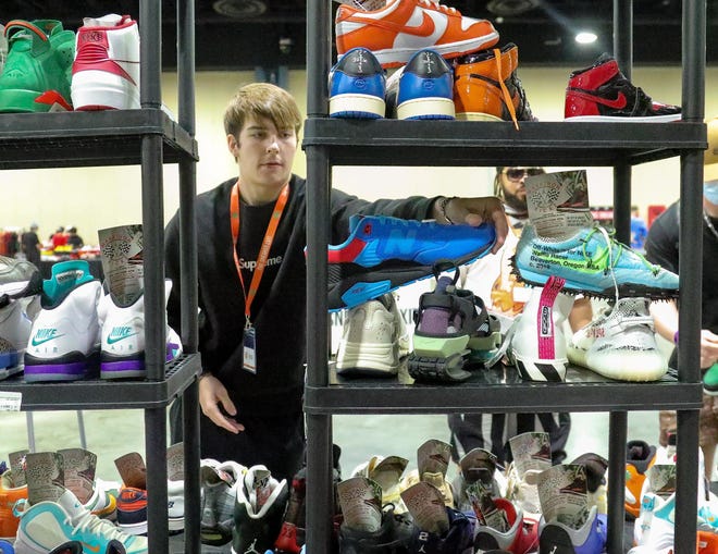 Boca resident Jared Pullman checks out sneakers at the South Carolina based Retro Store booth during the Sneaker Exit trade show at the Palm Beach Convention Center Sunday, January 16, 2022.