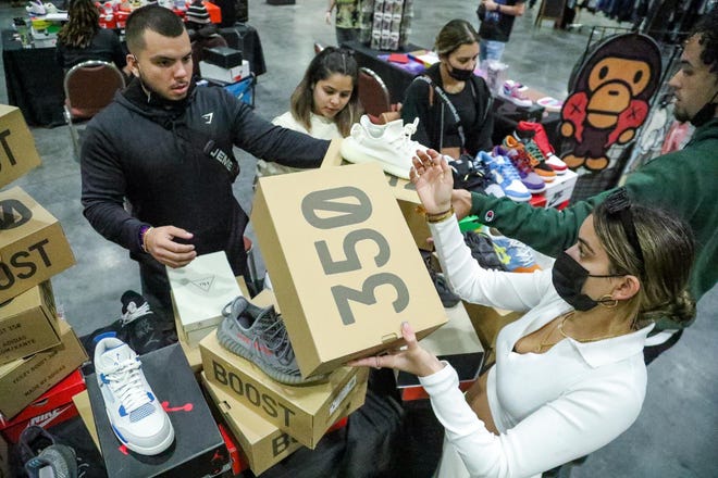 Members of the Hypehia shoe company organize boxes of sneakers during the Sneaker Exit trade show at the Palm Beach Convention Center Sunday, January 16, 2022.
