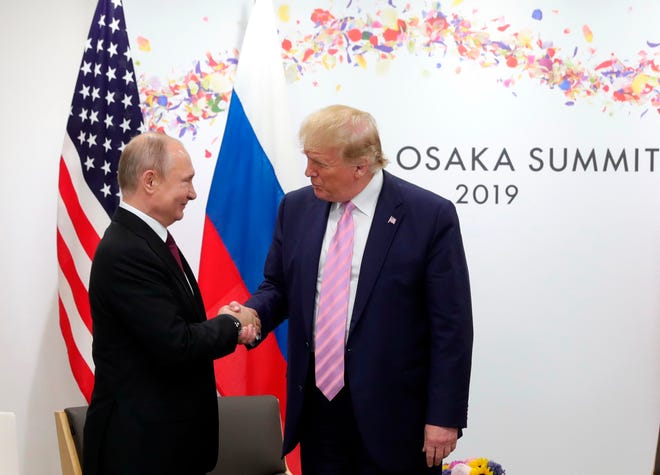 Presidents Donald Trump and Vladimir Putin greet each other at a summit in Osaka, Japan, in 2019.