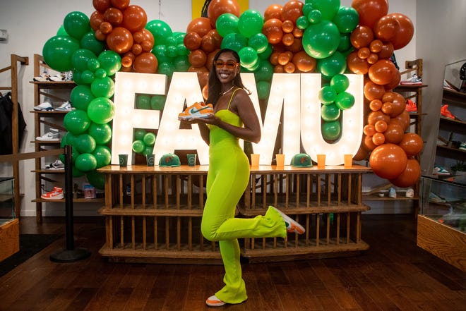 Caitlyn Davis, a Florida A&M University alumna, poses with a sneaker that she designed after she teamed up with Nike to create a shoe inspired by FAMU. The shoe was released as part of the "HBCU Dunk Lows" collection.