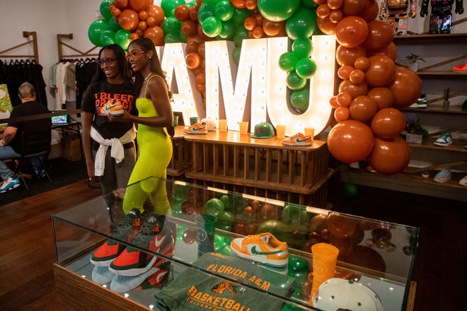 Caitlyn Davis, a Florida A&M University alumna, poses with a shopper who waited in line for the release of a sneaker David designed. David teamed up with Nike to create a FAMU inspired shoe, which was released as part of the "HBCU Dunk Lows" collection.
