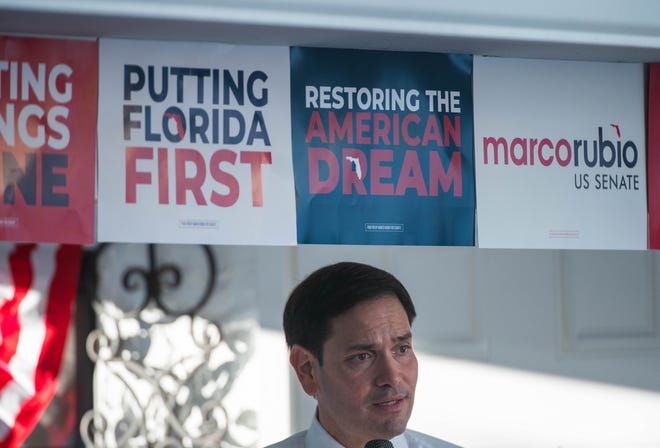 Campaign signs are seen above Senator Marco Rubio as he speaks to a crowd gathered for an event for his re-election campaign held at the Sims House on Thursday, October 27, 2022, in Jupiter, FL.