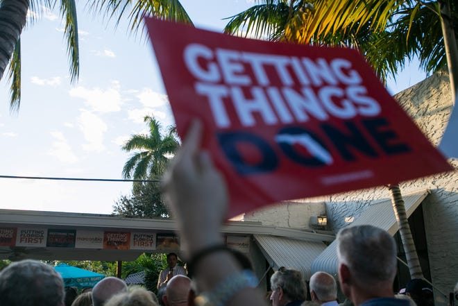 A Marco Rubio supporter waves a campaign sign as the senator speaks during an event for his re-election campaign held at the Sims House on Thursday, October 27, 2022, in Jupiter, FL.
