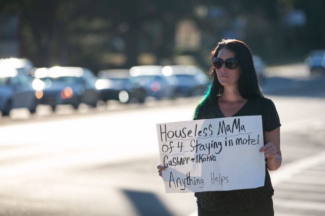 Danica Hively stands at the corner of Apalachee Parkway and Sutor Road outside of Wash Around the Clock. She was forced to panhandle for a second time that day when she realized that her family didnÕt have enough money to pay for their laundry to be washed. Her sign reads ÒHouseless mama of 4 staying in motel. CashApp $KatNQ Anything helps,Ó Friday, Oct. 21, 2022.